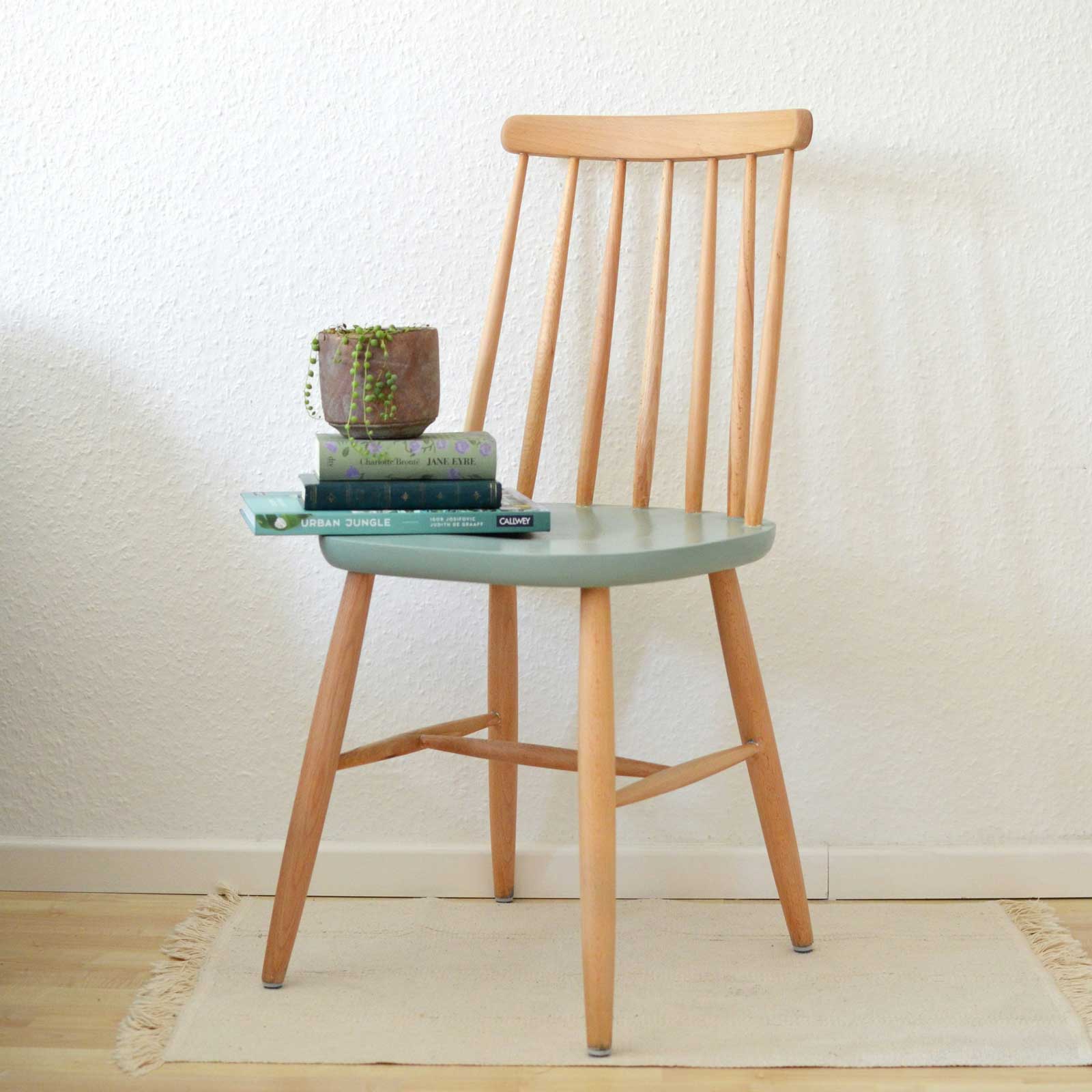Wooden chair with books and a plant on the seat